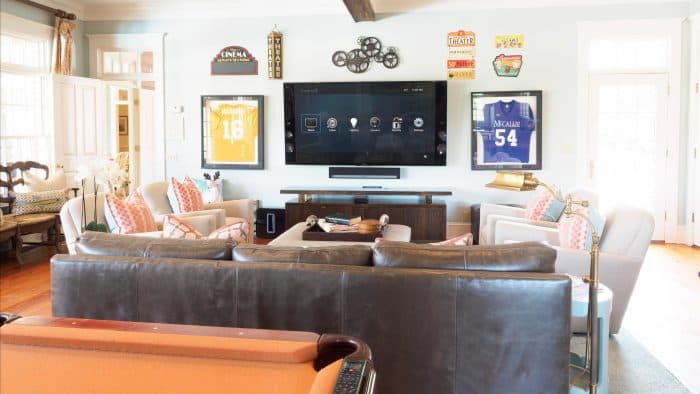 Dedicated home theater with two rows of leather recliners facing a projection screen